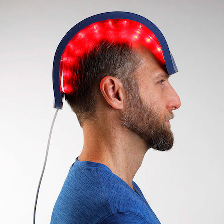 Side profile of a man wearing the Celluma RESTORE device for hair restoration treatment