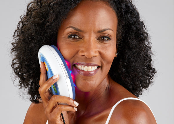 Woman using Celluma POD light therapy device for pigmentation