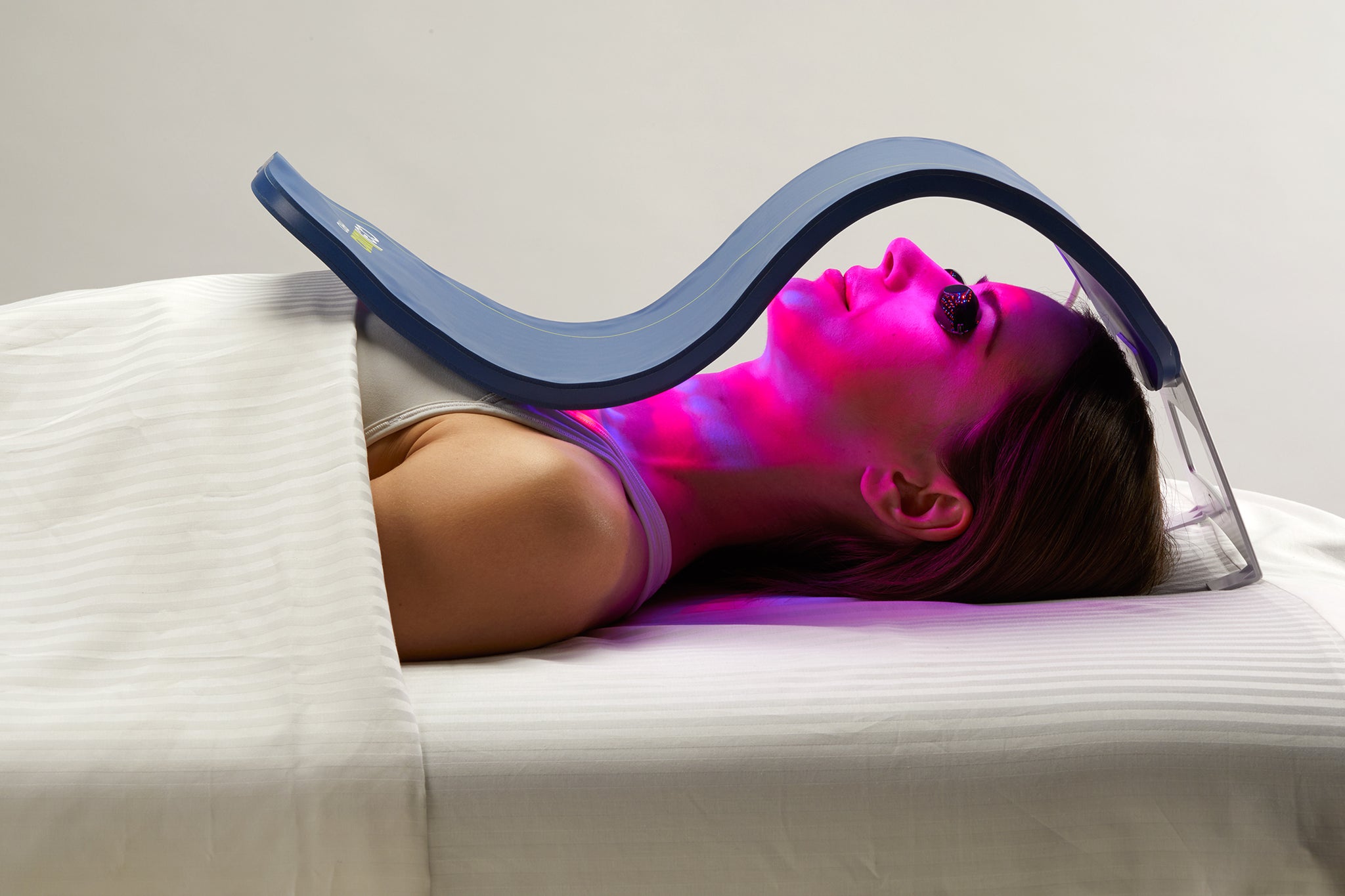 A woman uses the Celluma SKIN, an LED light therapy device for skin-related concerns such as wrinkles and acne