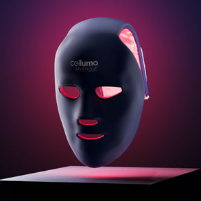 Celluma MYSTIQUE mask turned on and tilted slightly forward and floating above a flat surface.