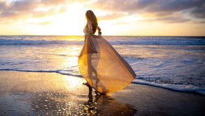Woman walking along the beach representing light therapy and a holistic approach to whole-body wellness