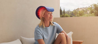 Woman sitting outside on a patio with a Celluma RESTORE on her head.