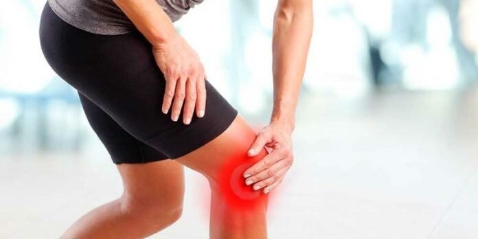 Person holding their knee due to flaring arthritis pain