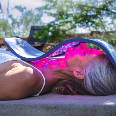 Woman using Celluma device in outdoor setting