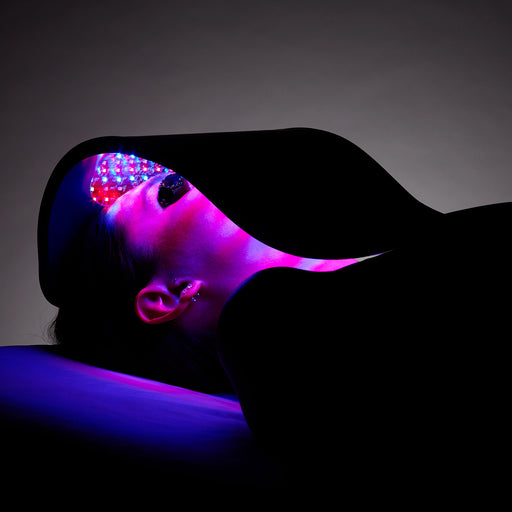 Person lying down using a Celluma light therapy device on their face