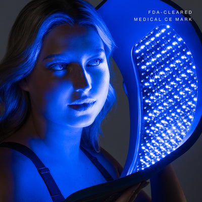 Woman using Celluma PRO PLUS blue light therapy panel for acne treatment. FDA-cleared LED device with Medical CE Mark for skin clarity and inflammation reduction.