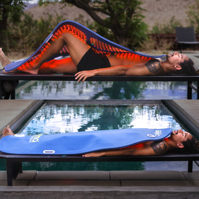 Man lying on a bench outdoors using a flexible Celluma LED light therapy panel for full-body red light treatment near a pool.