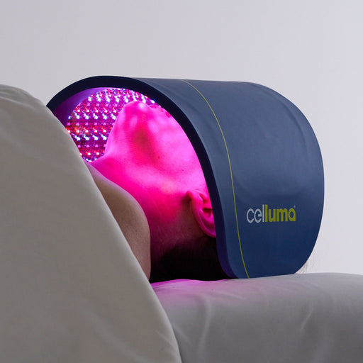 Celluma PRO PLUS LED red light therapy device used to treat fine lines and wrinkles for a woman laying on a massage bed