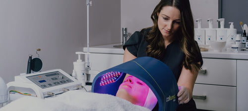 Aesthetician using a Celluma Pro light therapy device on client's face