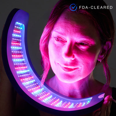 Person using a LED face and neck massager with visible FDA-Cleared label.